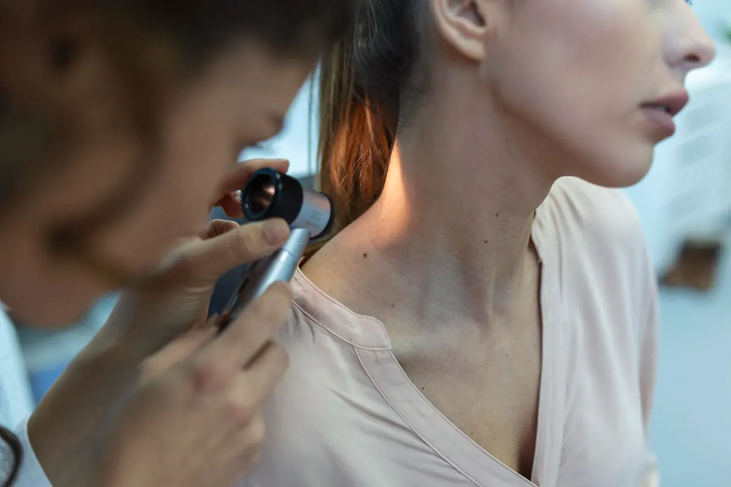 Doctor removing skin tag from a patient's face using cautery